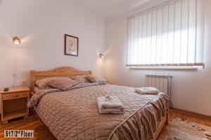 ein Schlafzimmer mit einem Bett mit zwei Handtüchern darauf in der Unterkunft Šišarka Apartmani Zlatibor in Zlatibor