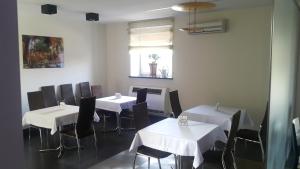 a restaurant with white tables and chairs and a window at Rever in Mielec