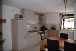 a kitchen with a table and a microwave on a refrigerator at Ferienwohnung Bayer in Kurort Gohrisch