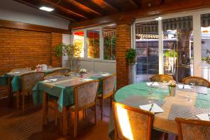 a dining room with tables and chairs and windows at Hotel & Apartments Rinaldo in Borgomanero