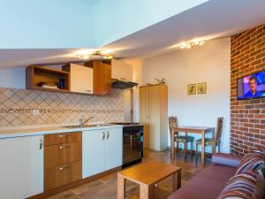 a kitchen and living room with a table and a couch at Apartments Špadići in Poreč