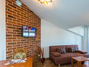 a living room with a couch and a brick wall at Apartments Špadići in Poreč