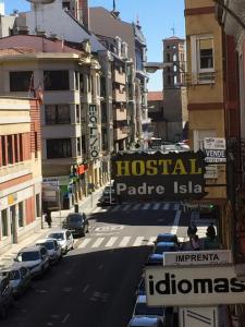 una calle de la ciudad con coches aparcados en la calle en Hostal Padre Isla 1, en León
