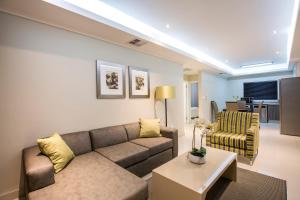 - un salon avec un canapé et une table dans l'établissement Savannah Park Luxury Apartments, à Durban