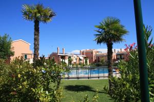 un resort con palme e piscina di Milano Dune Family Apartment a Lido di Jesolo