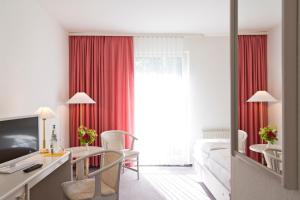 ロイターシュタット・シュターヴェンハーゲンにあるHotel Reutereicheのデスクとベッドルームが備わるホテルルームです。