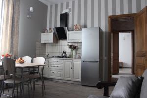 a kitchen with a white refrigerator and a table at Hotel Barin House готель с бомбосховищем in Sumy
