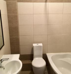 een badkamer met een wit toilet en een wastafel bij REM Apartments in Thessaloniki