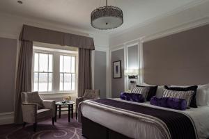 a bedroom with a large bed with purple pillows at Low Wood Bay in Windermere +93 photos