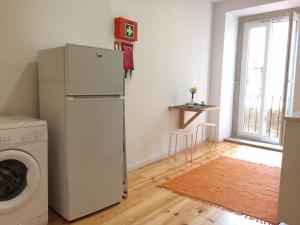 a kitchen with a refrigerator and a washing machine at Casa Amarela in Aveiro