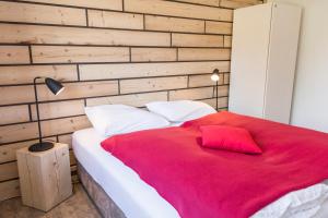 ein Schlafzimmer mit einer roten Decke auf einem Bett in der Unterkunft Kuckucksnest Todtnau-Muggenbrunn in Todtnau