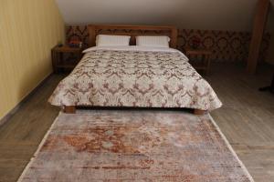 een slaapkamer met een bed met een tapijt op de vloer bij Barin House in Sumy