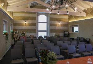 une grande pièce avec des chaises, des tables et un lustre dans l'établissement Antica Corte Casa Marini, à Polinago