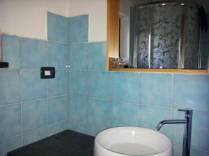 Baño de azulejos azules con lavabo y espejo en La Volpe e la Luna, en Mioglia