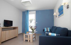 niebieski salon z niebieską kanapą i telewizorem w obiekcie Résidence Odalys Les Iles du Morbihan w mieście Baden