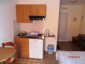 a kitchen with wooden cabinets and a white refrigerator at M&L Studios in Valeriános