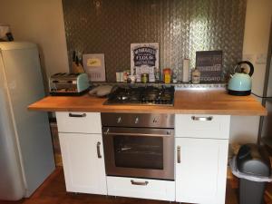 a kitchen with a stove and a counter top at Holly Cottage in Banbury