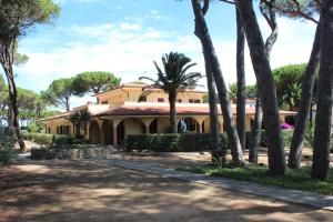 une maison avec des palmiers devant elle dans l'établissement Residence Villa La Pineta, à Cavo