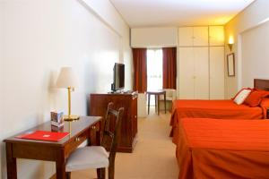 a hotel room with two beds and a desk and a television at Provincial Plaza Hotel in Salta +47 photos