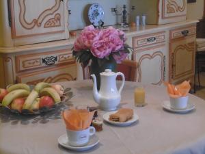 a table with a vase of flowers and a bowl of fruit at Hôtel La Flore in Villefranche-sur-Mer