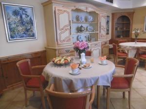 a dining room with a table with a bowl of fruit at Hôtel La Flore in Villefranche-sur-Mer