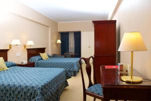Habitación de hotel con 2 camas y mesa con lámpara en Provincial Plaza Hotel en Salta
