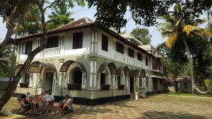 a group of people sitting in chairs in front of a building at Lake County Heritage Home in Cochin