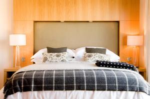 a bedroom with a large bed with two lamps at Waterford Castle Hotel Lodges in Waterford