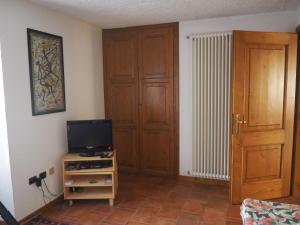 マクニャーガにあるmonolocale in villaのリビングルーム(テレビ、木製のドア付)