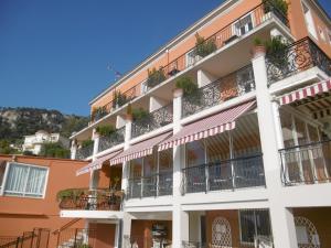 a building with balconies and plants on it at Hôtel La Flore in Villefranche-sur-Mer