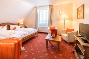 ein Hotelzimmer mit einem Bett und einem Koffer in der Unterkunft Airport Fashion Hotel in Düsseldorf