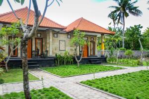 a house with a garden in front of it at DeIndra Nusa Inn in Nusa Lembongan