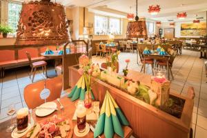 ein Speisesaal mit Tischen und Stühlen und ein Restaurant in der Unterkunft Airport Fashion Hotel in Düsseldorf