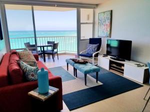 a living room with a red couch and a tv at Marbella del Caribe 1608 in San Juan