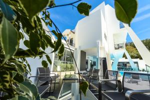 een wit huis met stoelen op een balkon bij Villamar Style Maison in Nazaré