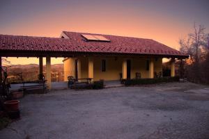 ein Haus mit einem roten Dach und einer Terrasse in der Unterkunft Agriturismo Ai Guiet in Superga