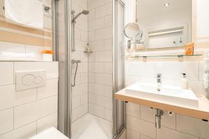 ein Badezimmer mit Dusche und Waschbecken in der Unterkunft Airport Fashion Hotel in Düsseldorf