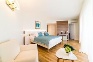 a bedroom with a bed and a living room at Hôtel Hélios in Juan-les-Pins