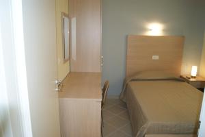 - une petite chambre avec un lit et une petite armoire dans l'établissement Guest House Golfo Xifonio, à Augusta