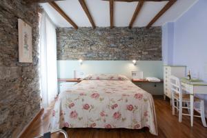 a bedroom with a bed and a stone wall at L'Ancora in Riomaggiore
