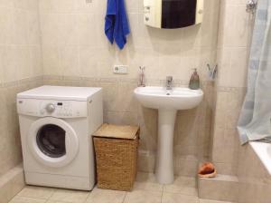 een badkamer met een wasmachine en een wastafel bij Bright room near International Exhibition Centre in Kiev
