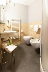 a bathroom with two sinks and a toilet and a tub at L'Ancora in Riomaggiore