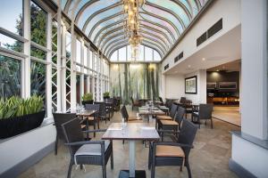 a restaurant with tables and chairs and a glass ceiling at Leonardo Hotel East Midlands Airport in Castle Donington