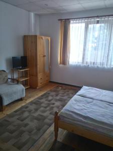 a bedroom with a bed and a large window at Proboyski Guest House in Tryavna