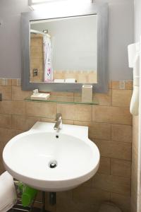 
a white sink sitting under a mirror in a bathroom at L'Ancora in Riomaggiore

