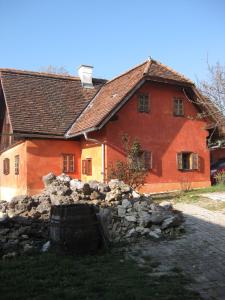 ein großes rotes Haus mit einer Steinmauer davor in der Unterkunft Ferienwohnungen Sonnenberg in Ratsch an der Weinstraße