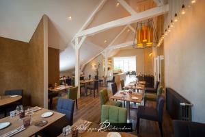 a dining room with wooden tables and chairs at Logis Hôtel Le Cheval Blanc in Langres