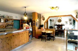 a restaurant with a bar and a table and chairs at Albergo Al Pino in Enego