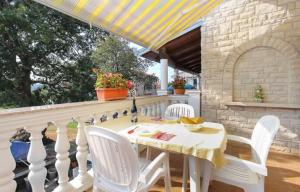 een witte tafel en stoelen op een terras met een dak bij Apartments Lili in Medulin