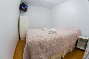 1 dormitorio con 1 cama con 2 toallas en Isla de Lagos I en Ushuaia
